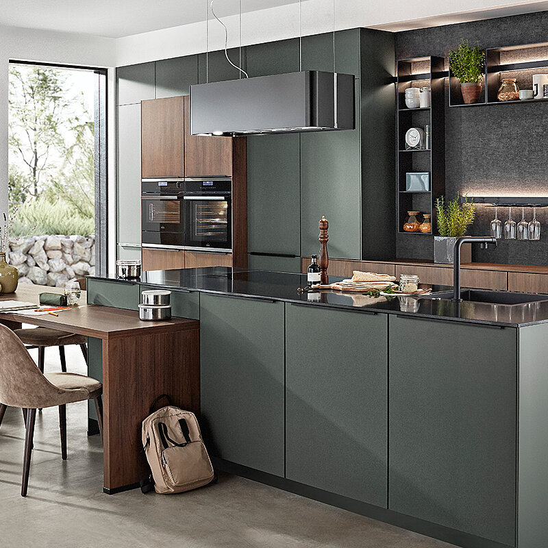 Moderne Küche mit einer großen Insel und einem Esstisch in einem hellen, einladenden Raum.