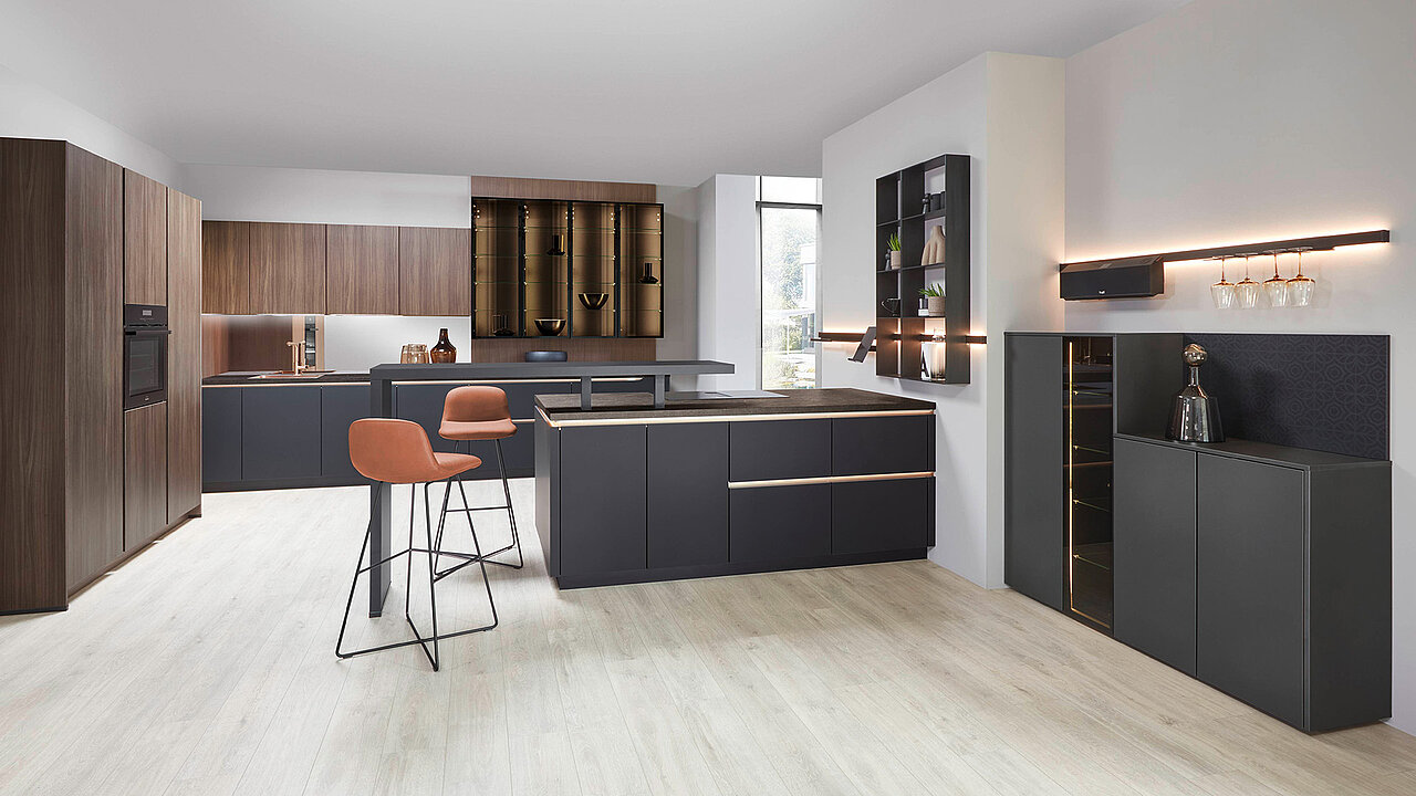 Eine moderne Küche mit einer Bar und einem Barhocker im Vordergrund.
