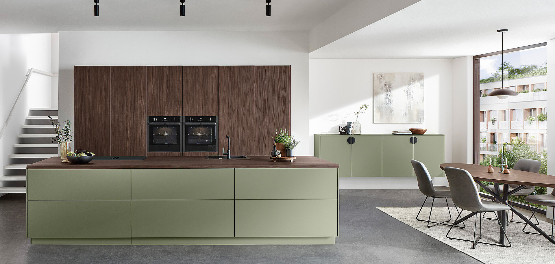 Moderne Küche mit grünen Schränken und Holzböden, die ein einladendes und stilvolles Ambiente schaffen.